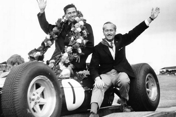 Colin-Chapman-former-chief-of-Lotus-Racing-celebrates-with-driver-Jim-Clark-after-his-win-in-the-1964-European-Grand-1863483